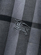 Embroidered dragon logo on gray and black plaid fabric, close-up