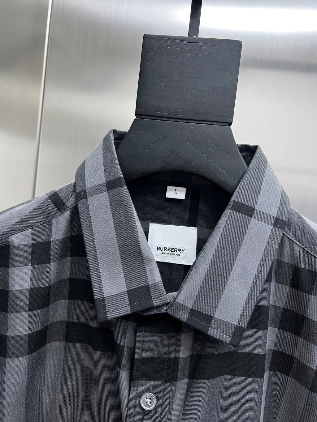 Plaid button-up shirt with gray check pattern, close-up of collar and front buttons
