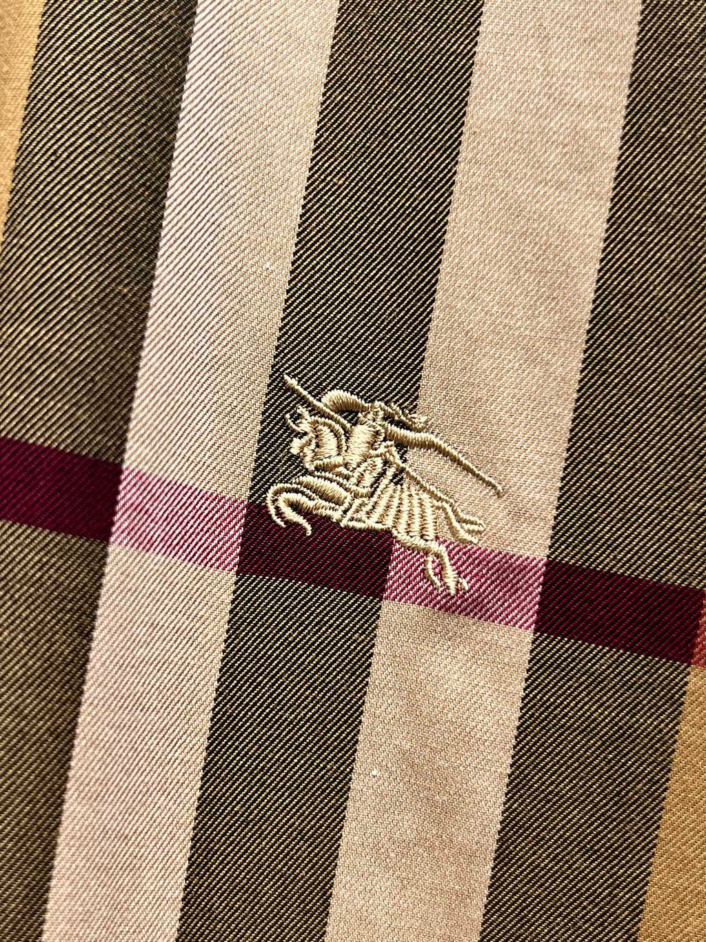 Burberry embroidered horse logo on beige, navy, and maroon plaid fabric