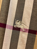 Burberry embroidered horse logo on beige, navy, and maroon plaid fabric