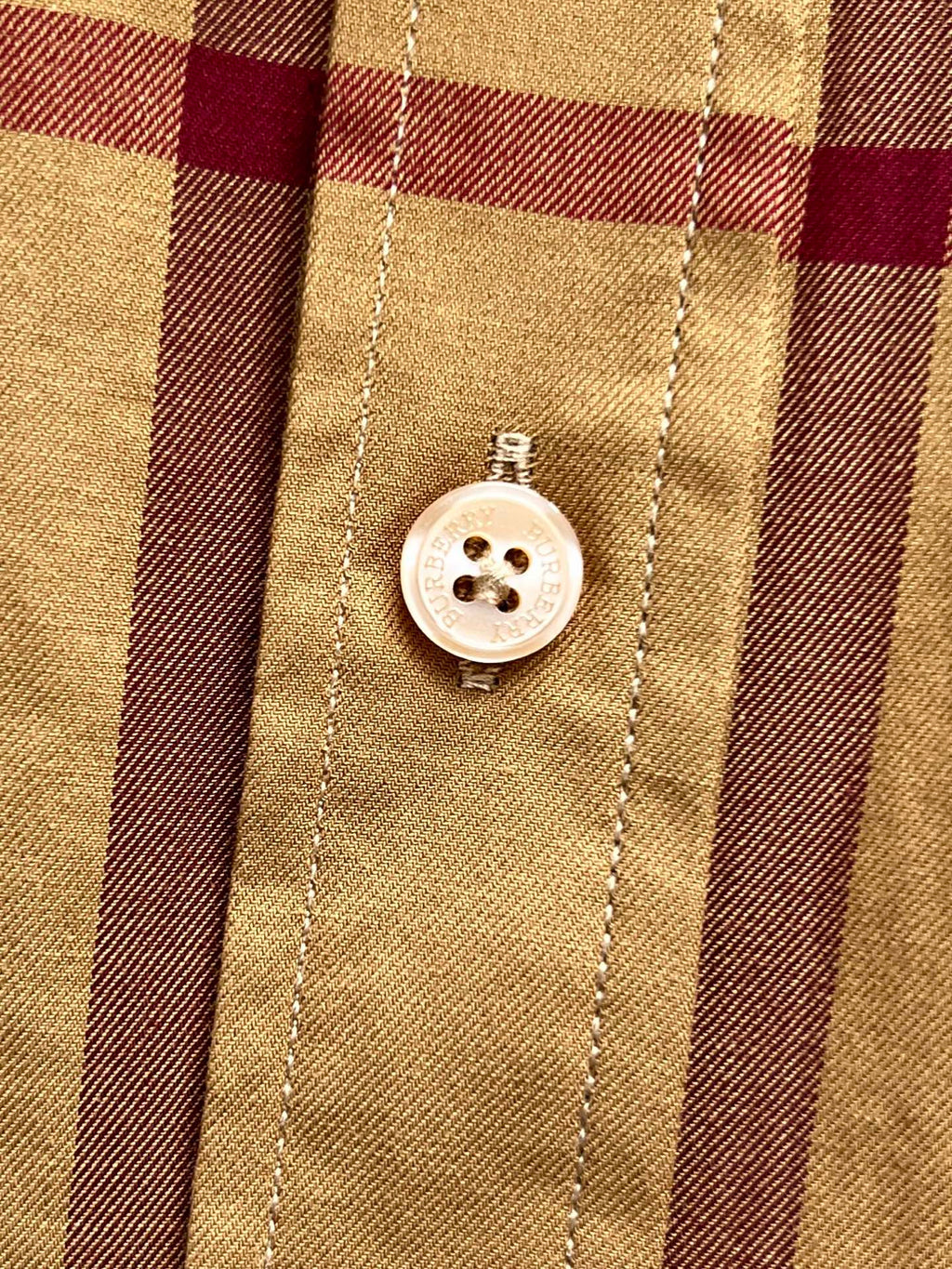 Placket buttons on beige Burberry plaid shirt, white button with four holes