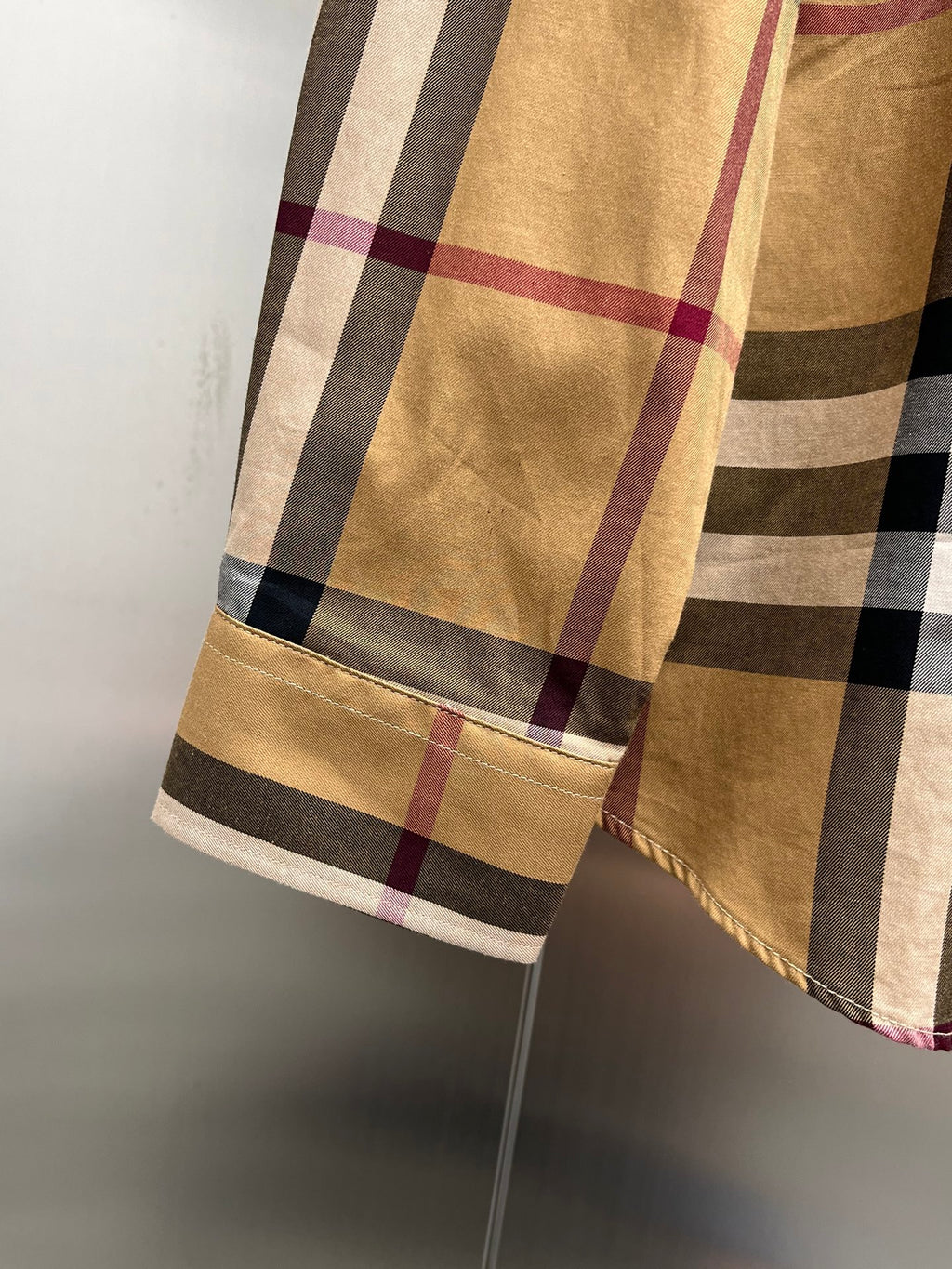 Burberry plaid long-sleeve shirt hem with light trim at sleeve cuff