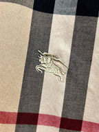 Burberry embroidered horse logo on beige and navy plaid fabric