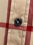 Burberry shirt button on beige, navy and red plaid fabric