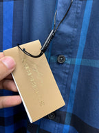 Burberry long-sleeve check shirt detail, hang tag held by hand