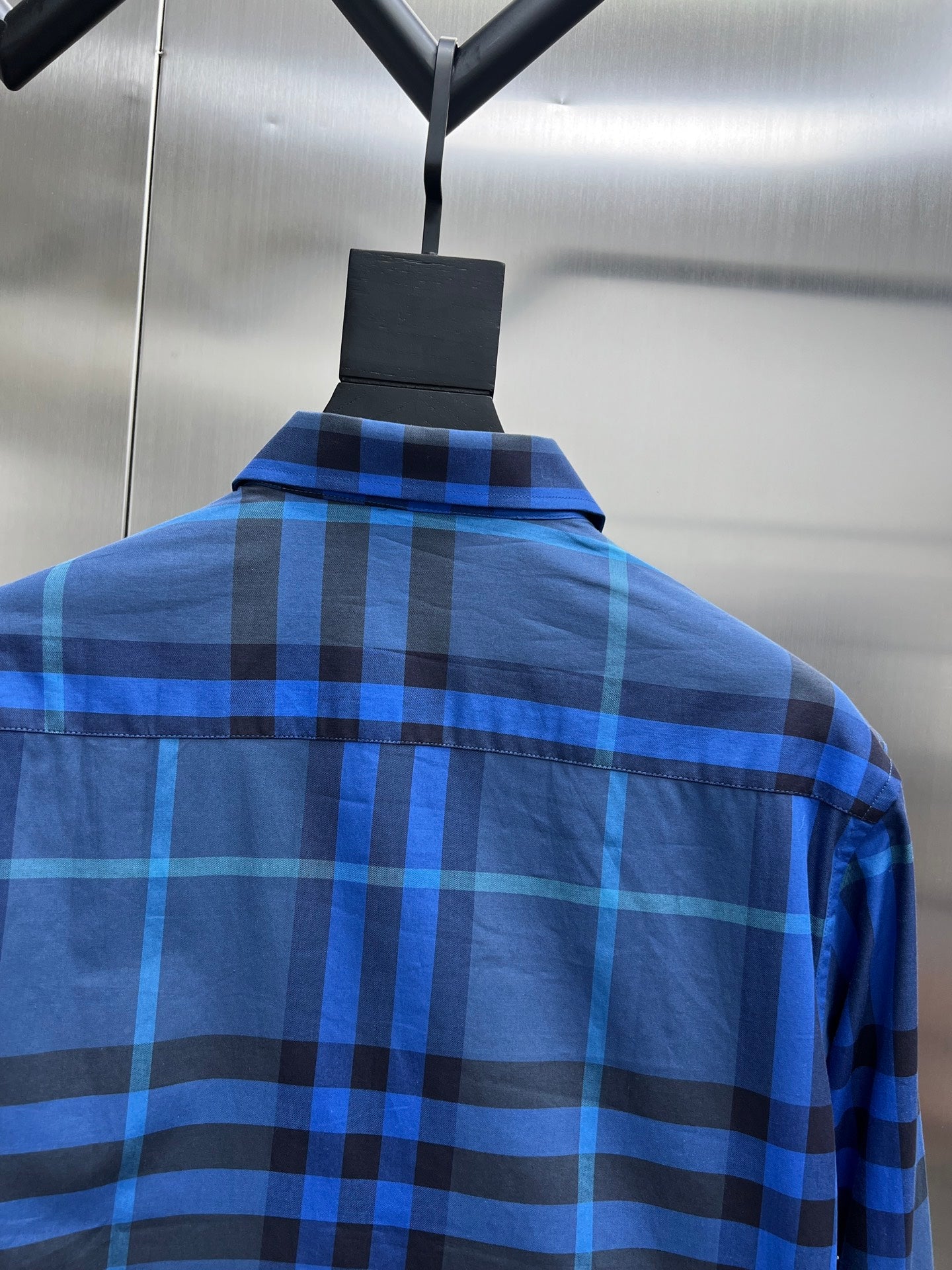 Blue/black plaid long-sleeve shirt back with collar.
