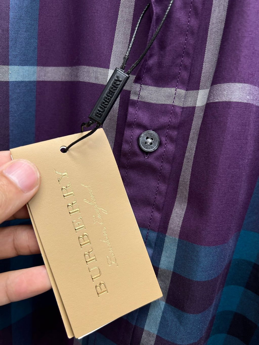 Burberry plaid shirt with paper hang tag near button placket