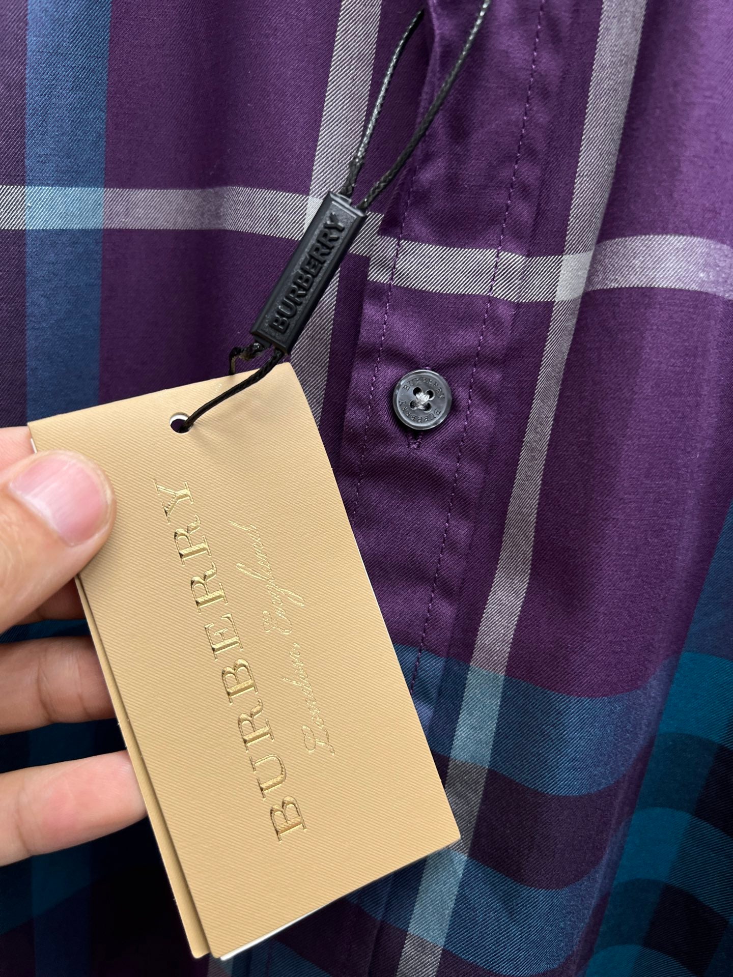 Burberry plaid shirt with paper hang tag near button placket