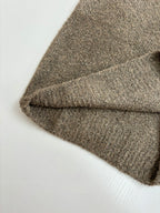 Brown knit sweater sleeve and hem detail, soft textured fabric