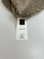 Care label at hem of brown knit sweater with size M and material info