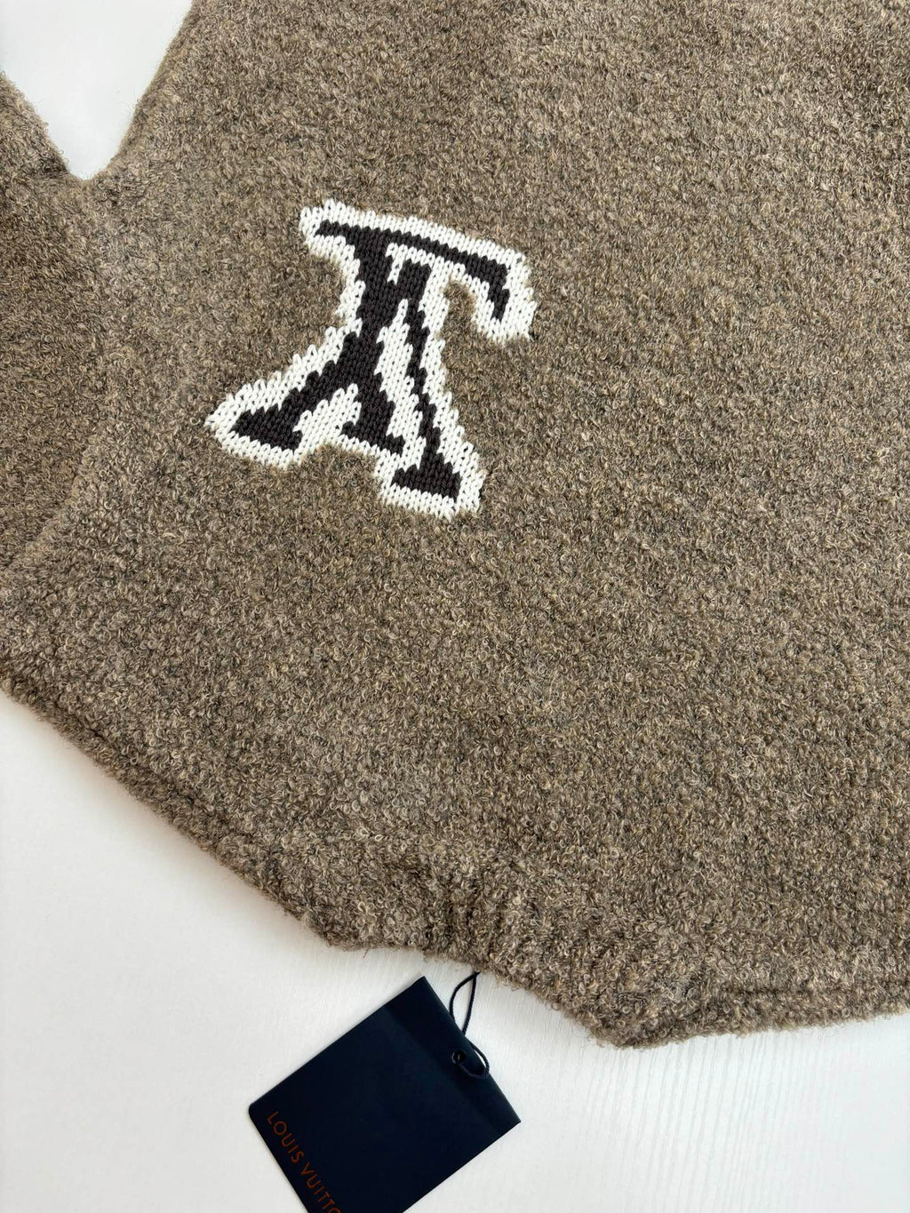Brown knit sweater with white LV monogram logo, cropped close-up