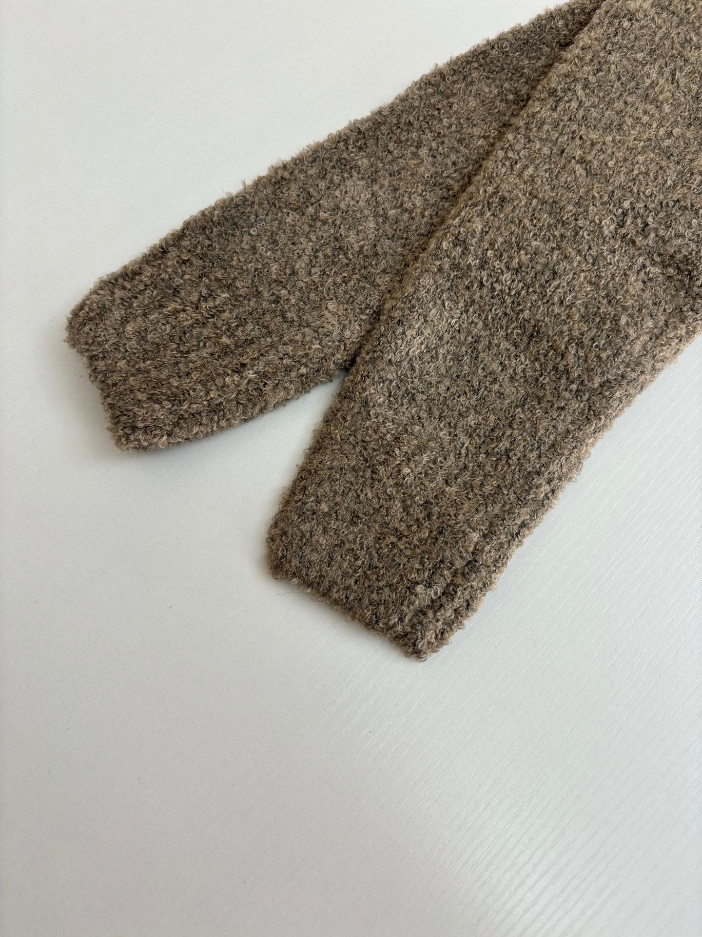 Brown knit sweater folded with sleeves and hem detail