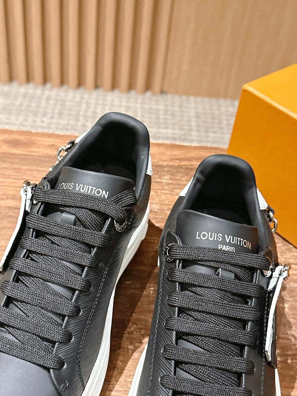 Louis Vuitton lace-up sneakers, black, white sole, front view with chain charm