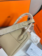 Taupe leather handbag strap with flap clasp and engraved silver hardware detail