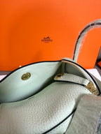 Hermes mint leather handbag interior view with gold-tone clasp and handles