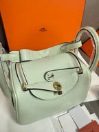 Hermes mint leather handbag with front flap closure and gold-tone hardware