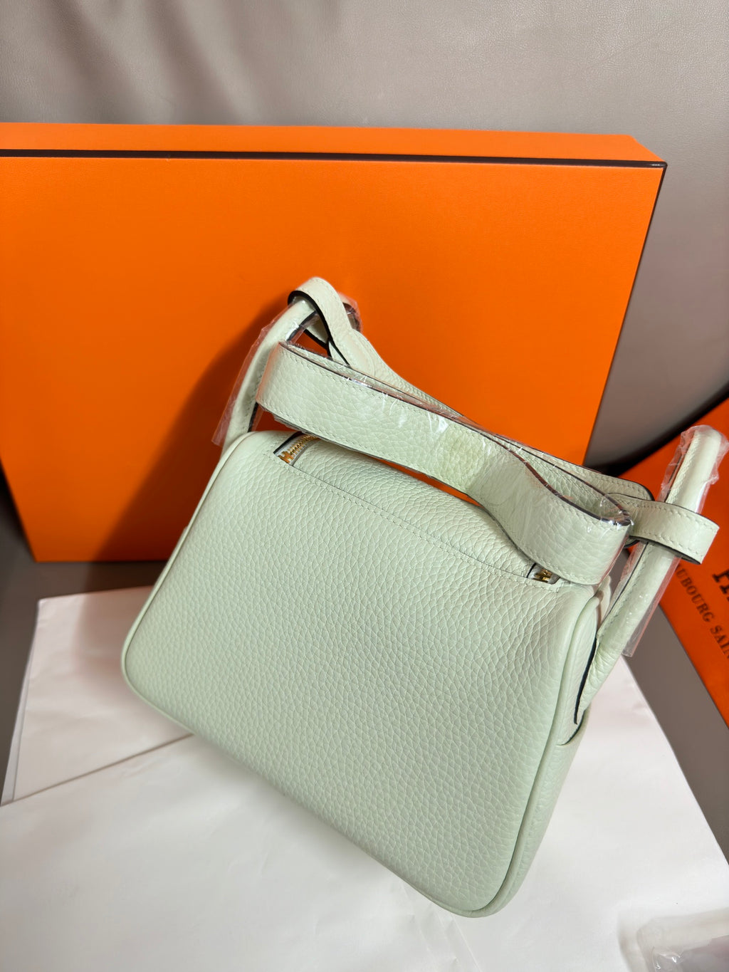 Hermes mint leather handbag angled view with shoulder strap and front flap