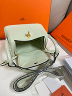 Hermes mint leather handbag with front flap, zipper pocket, and crossbody strap
