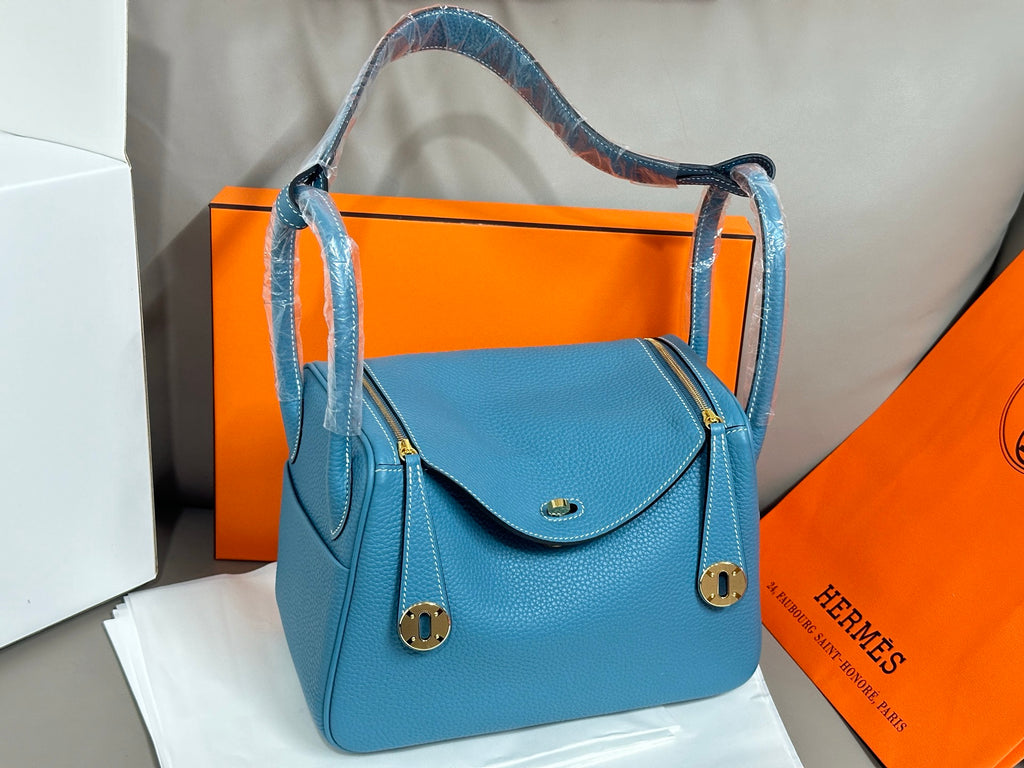 Hermes blue leather handbag with curved top flap and gold-tone clasp