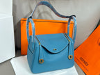 Hermes blue leather handbag with curved top flap and gold-tone clasp