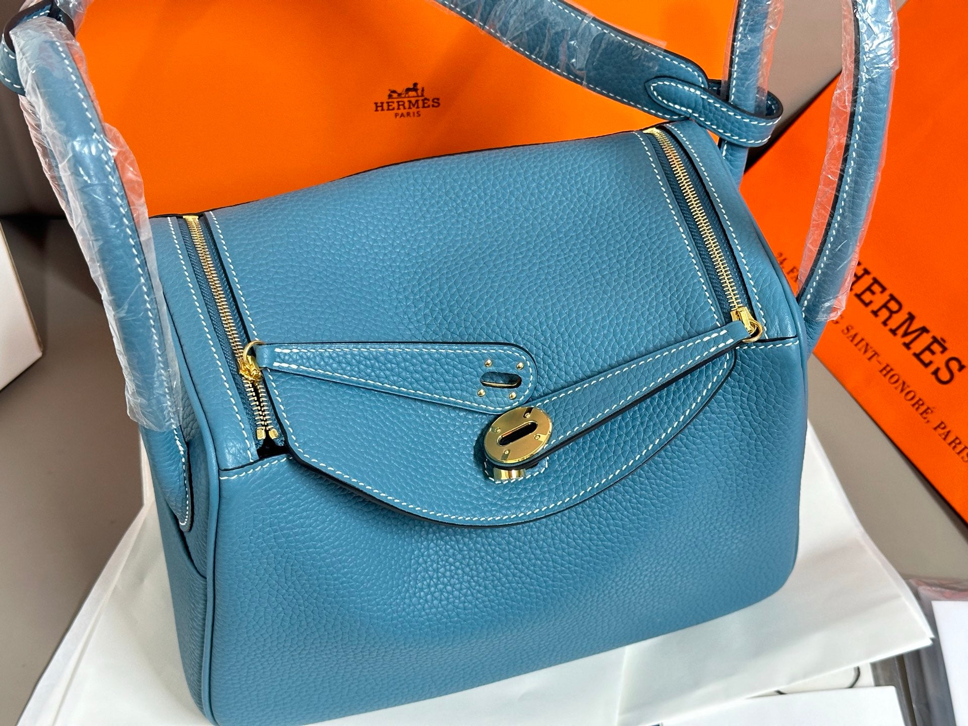 Hermes blue leather handbag close-up with front clasp and stitched flap
