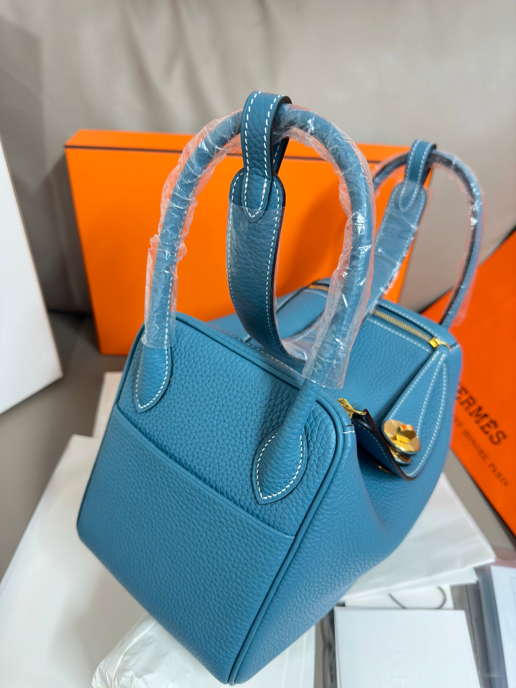 Hermes blue leather handbag with curved handles and front flap pocket