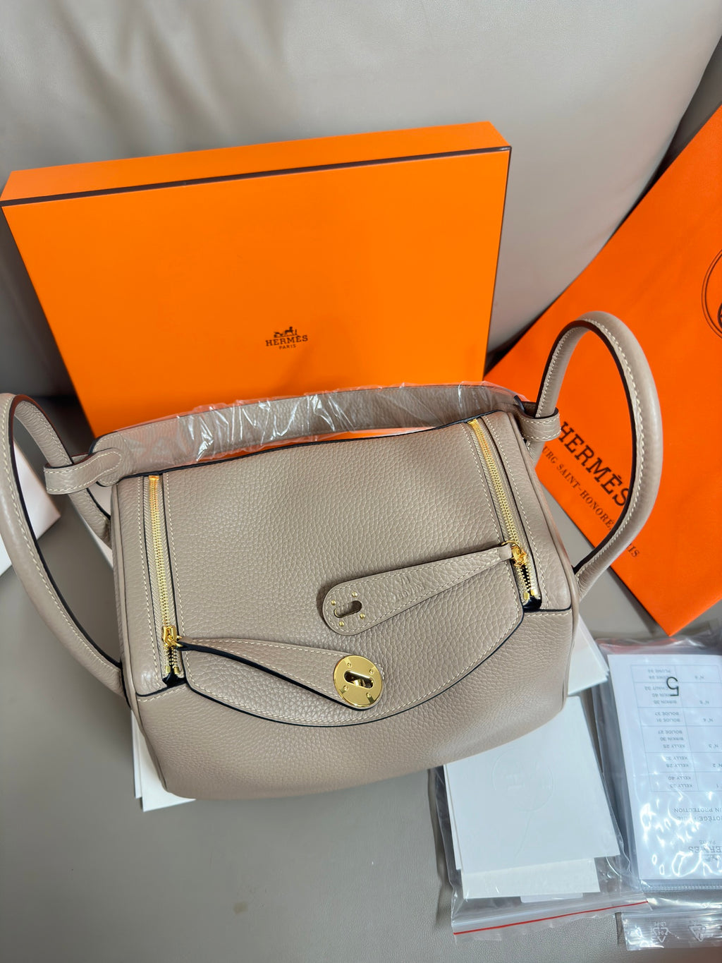 Hermes light gray leather crossbody-style handbag with flap and gold-tone lock hardware