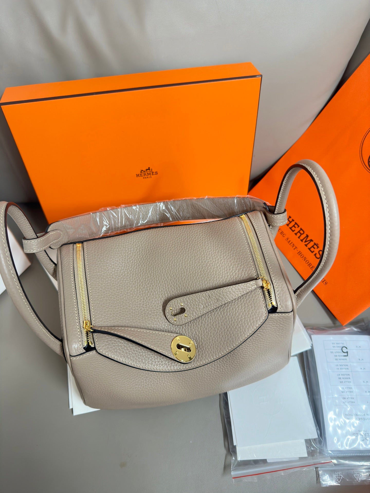 Hermes light gray leather crossbody-style handbag with flap and gold-tone lock hardware