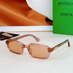 Bvlgari sunglasses: transparent pink frames with amber lenses and rose-gold detail.