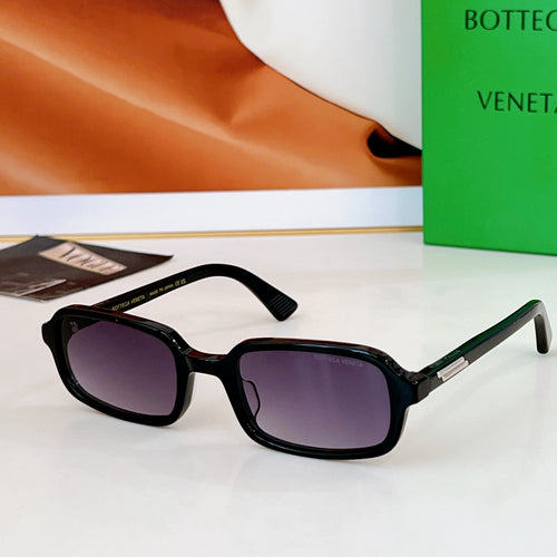 Bvlgari sunglasses: black frames with purple-tinted lenses and gold-tone detail.