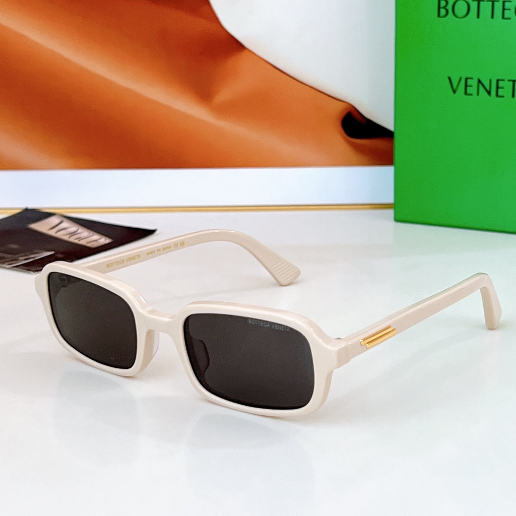 Bvlgari sunglasses: white frames with black lenses and gold-tone temple detail.