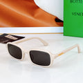 Bvlgari sunglasses: white frames with black lenses and gold-tone temple detail.