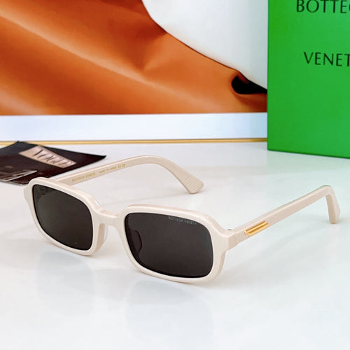 Bvlgari sunglasses: white frames with black lenses and gold-tone temple detail.