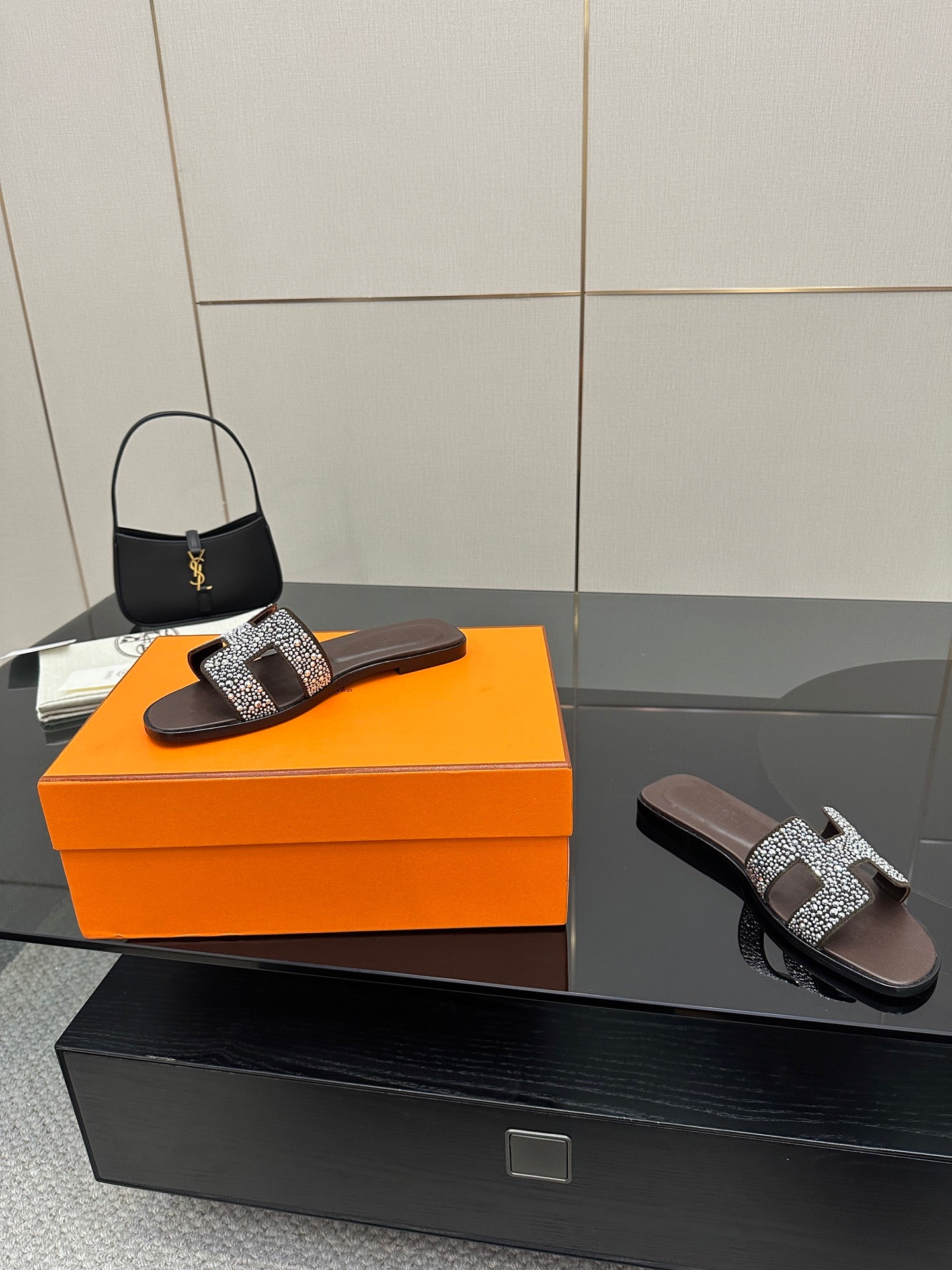 Hermes ladies slide sandals, black with silver rhinestone H buckle, side angle