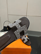 Hermes ladies slide sandal close-up, black with silver rhinestone H buckle detail
