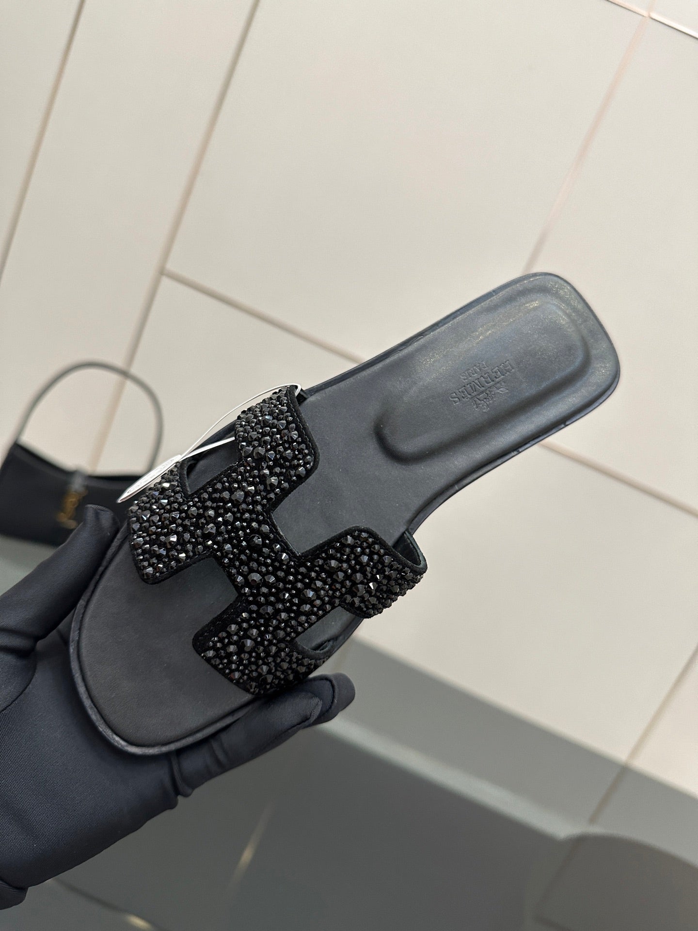 Black slide sandal close-up of footbed and rhinestone strap detail