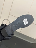Black slide sandal outsole view in hand, textured tread and label