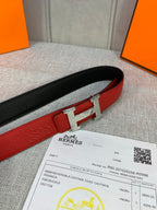 Reversible belt: red face with black reverse, silver H buckle and leather texture.