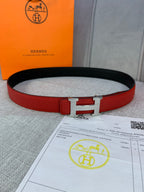 Red leather belt with silver H buckle and black reverse side, shown with certificate.