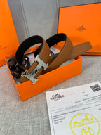 Brown reversible leather belt with silver H buckle, laid in open box