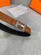 Reversible leather belt with brown strap, black underside, silver buckle close-up