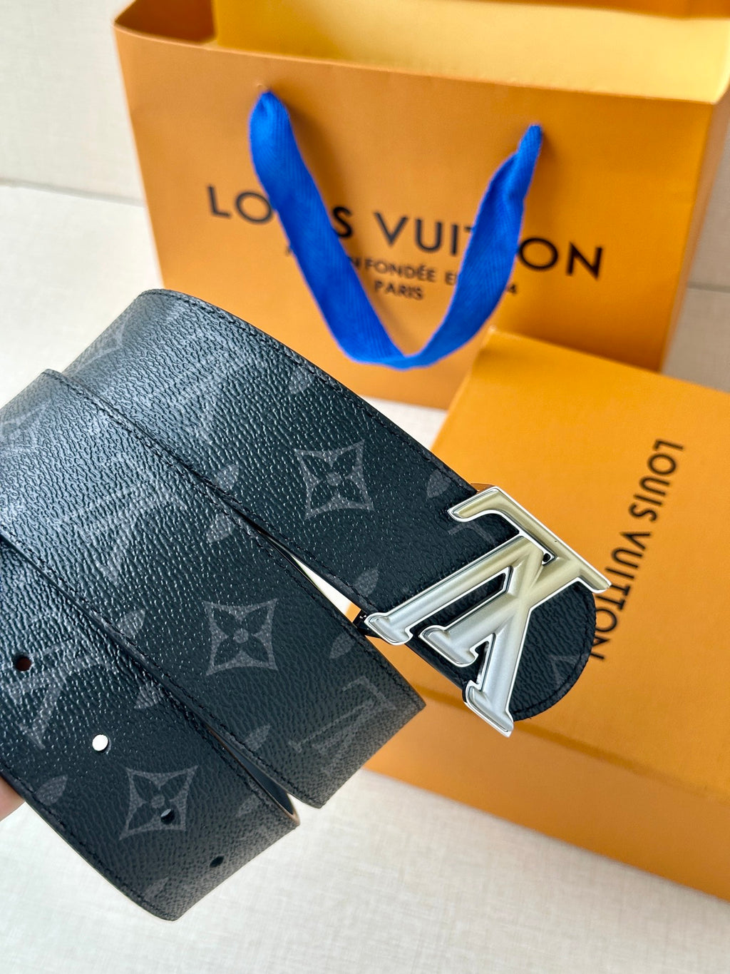 Louis Vuitton belt side view: dark monogram strap with silver LV buckle