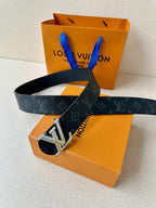 Louis Vuitton belt draped on box: dark monogram strap with silver LV buckle