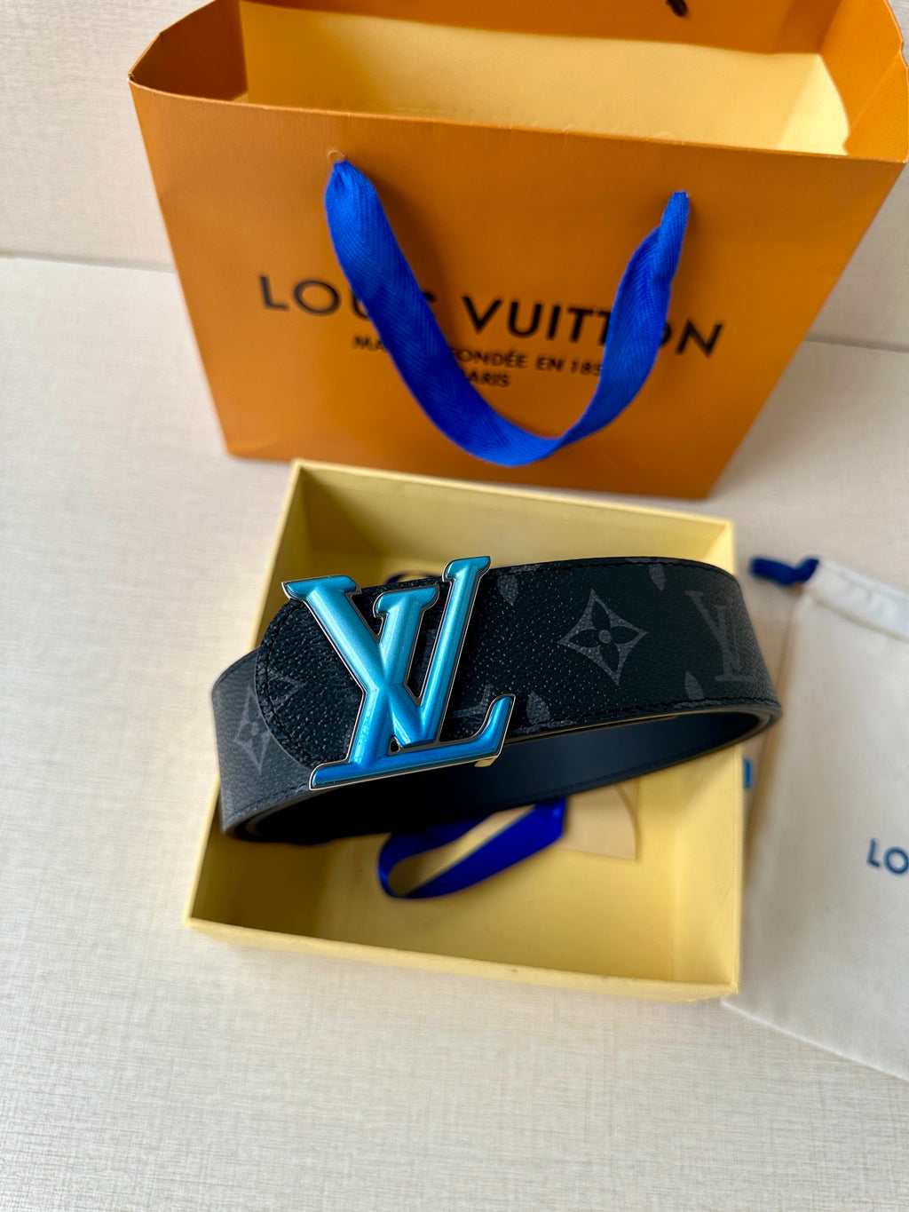 Louis Vuitton monogram belt with oversized blue LV buckle on dark strap
