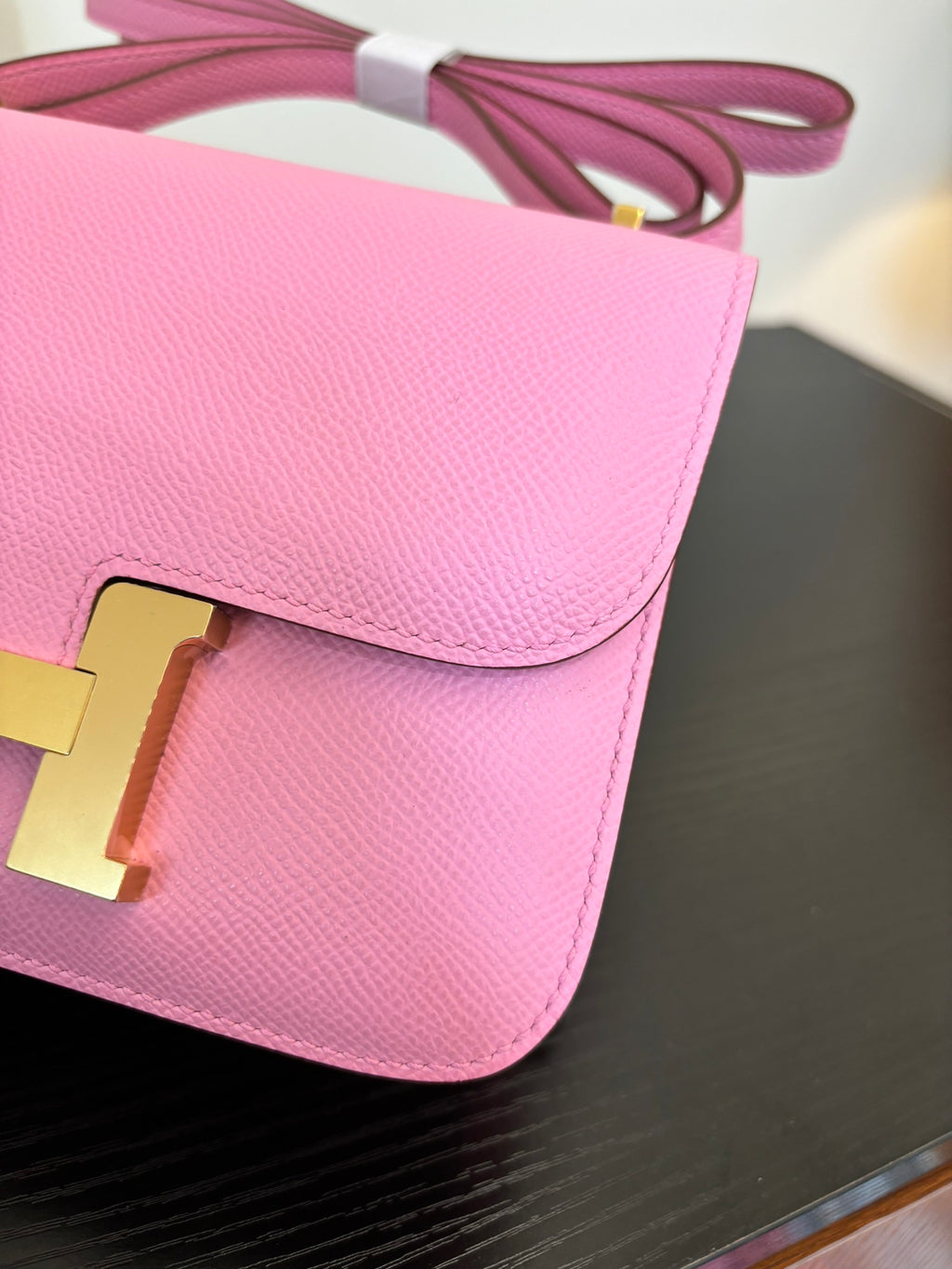 Pink leather flap handbag with gold H clasp hardware, close-up