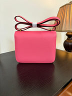 Hermes pink leather mini shoulder bag with flap and gold H hardware, front view.
