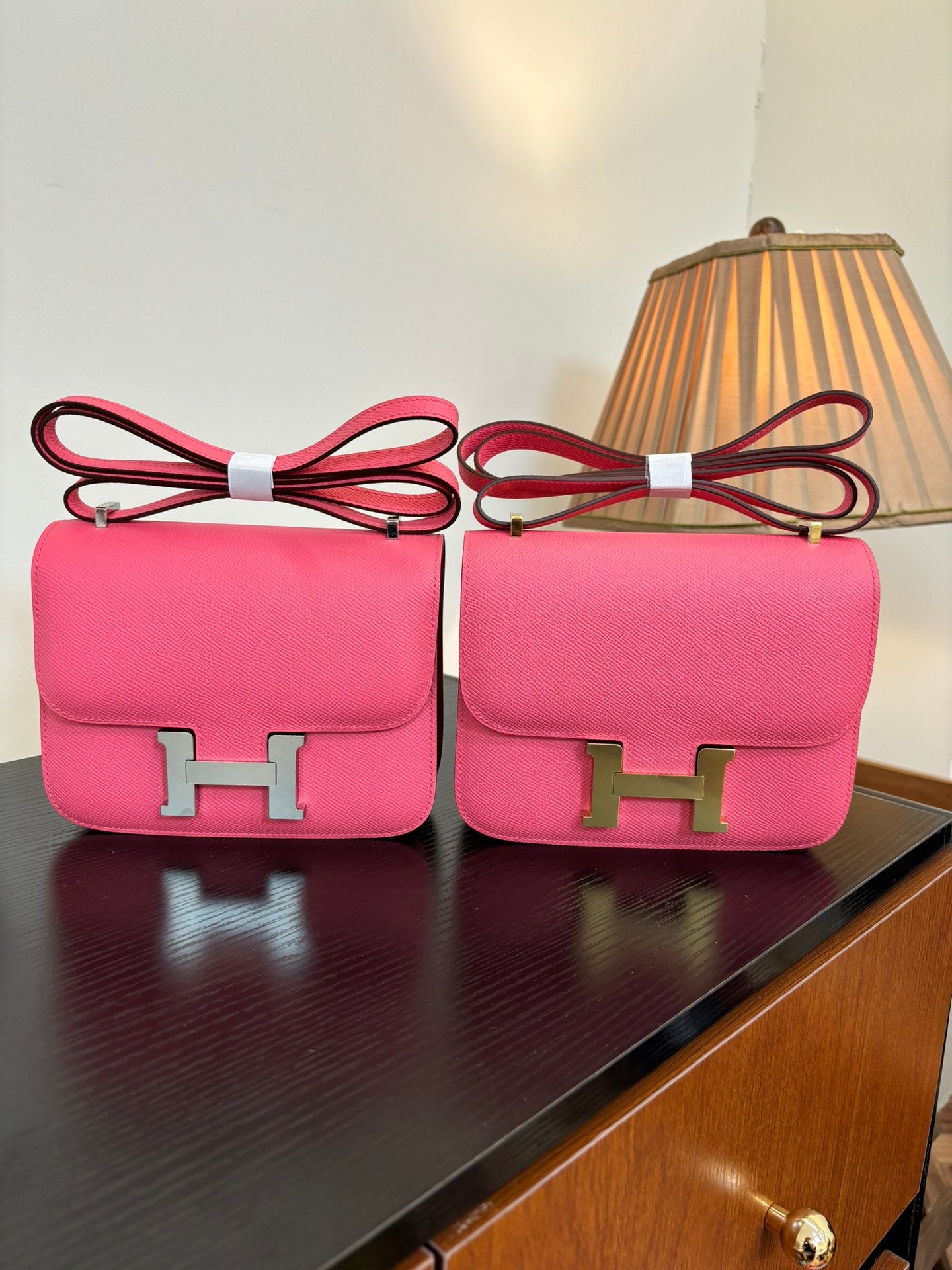 Hermes pink mini bag with flap and gold H clasp, red crossbody strap.