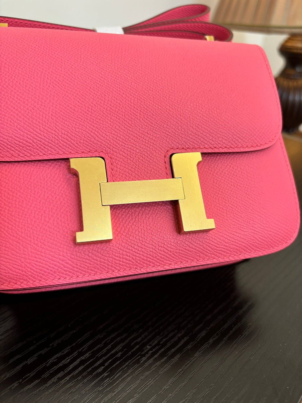 Hermes pink mini bag close-up of gold H clasp on front flap.
