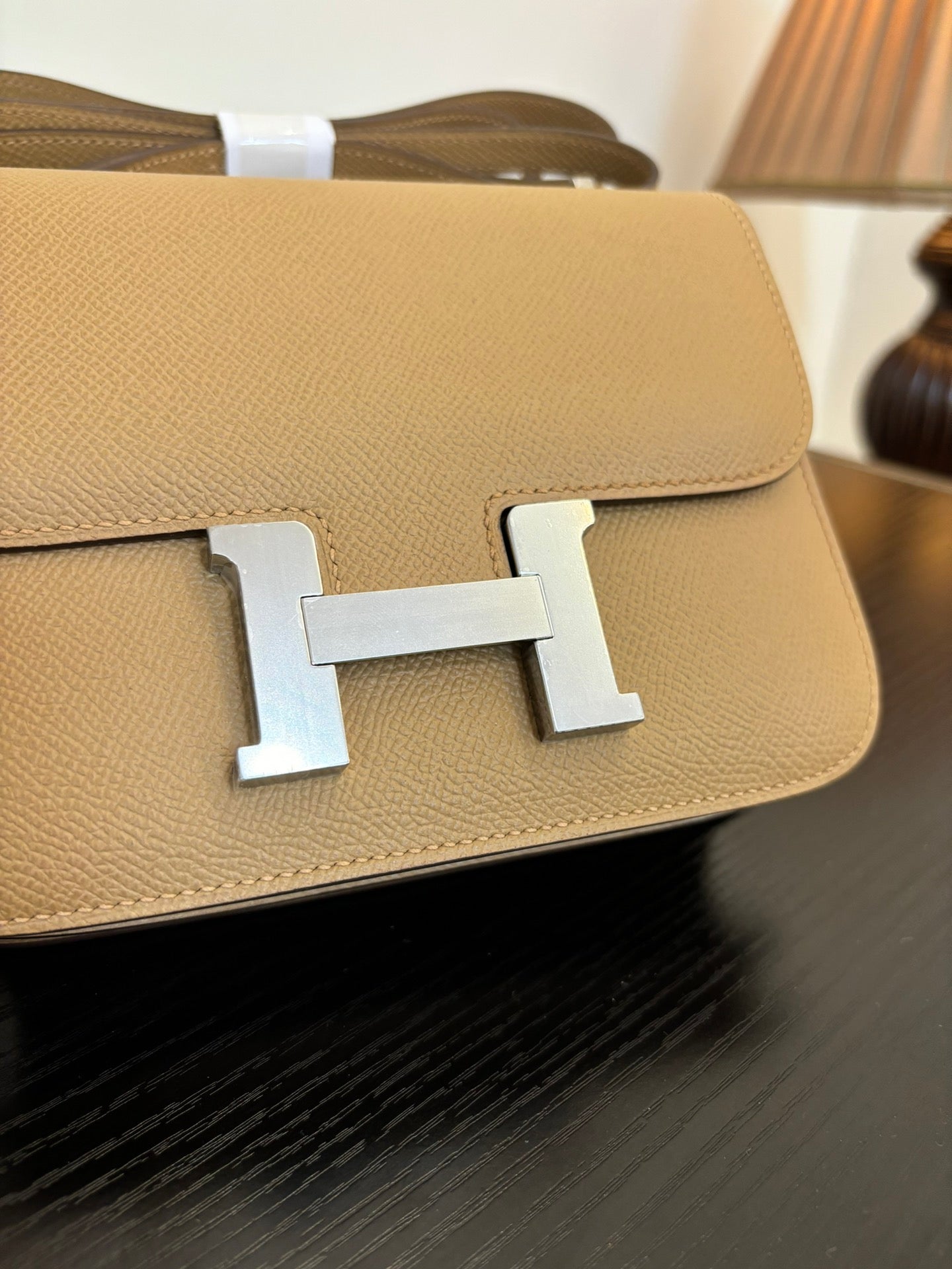 Beige leather-look bag close-up of front H clasp