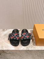 Pair of Louis Vuitton slide sandals in black with multicolor monogram print.